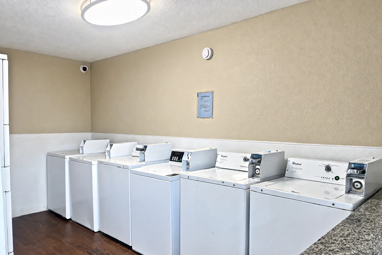 The shared laundry room, with a row of coin operated washers and dryers.